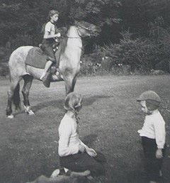 Mary Lou riding a horse at Hogland House with Kay and their brother, Al