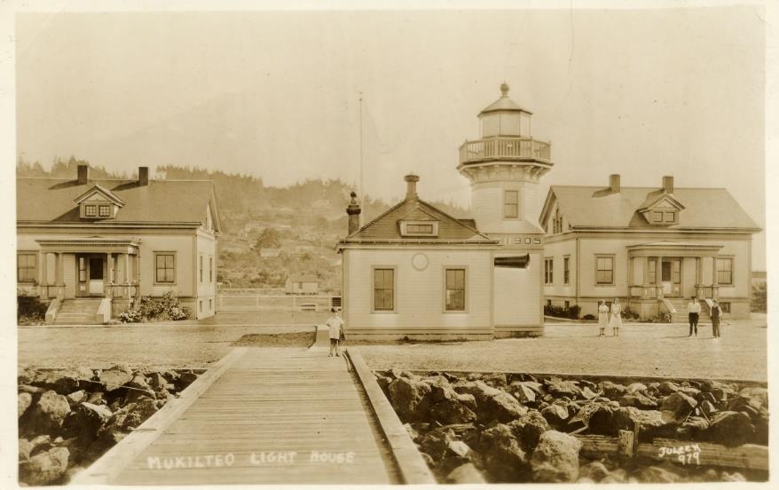 Small children standing in yard near lighthouse and quarters buildings with dock in foreground at Mukilteo Light Station 1934